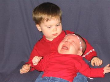 Audrey with her mom's side's cousin.  She is not happy in this picture.  He's not exactly jumping for joy either...
