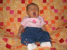 This is Audrey on the quilt that Laura made for her.  She was starting to get sleepy.  Having to be so cute is hard work, you know.