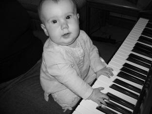 Audrey also really likes the real piano. She goes to town. Here she's sitting on Mom's lap playing a fugue. Yes, she's a prodigy.